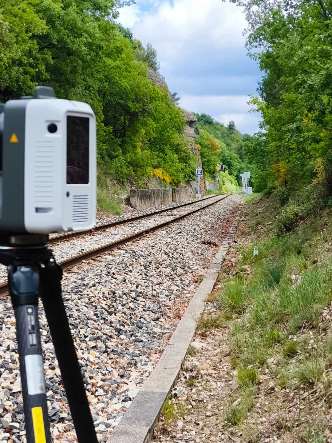 Scanner laser positionné sur une voie ferrée en forêt